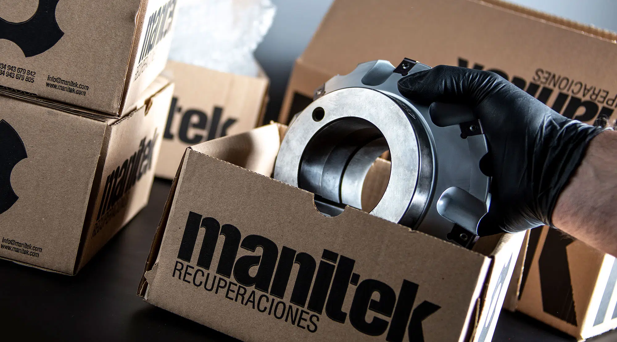 Mano que mete una herramienta de corte recuperada dentro del packaging de Manitek