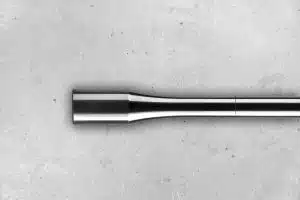 Detalle de una probeta de fatiga sobre una superficie de cemento